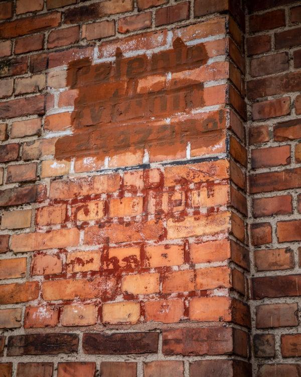 ceglana ściana z zamalowanym napisem "Palenie tytoniu zakazane"