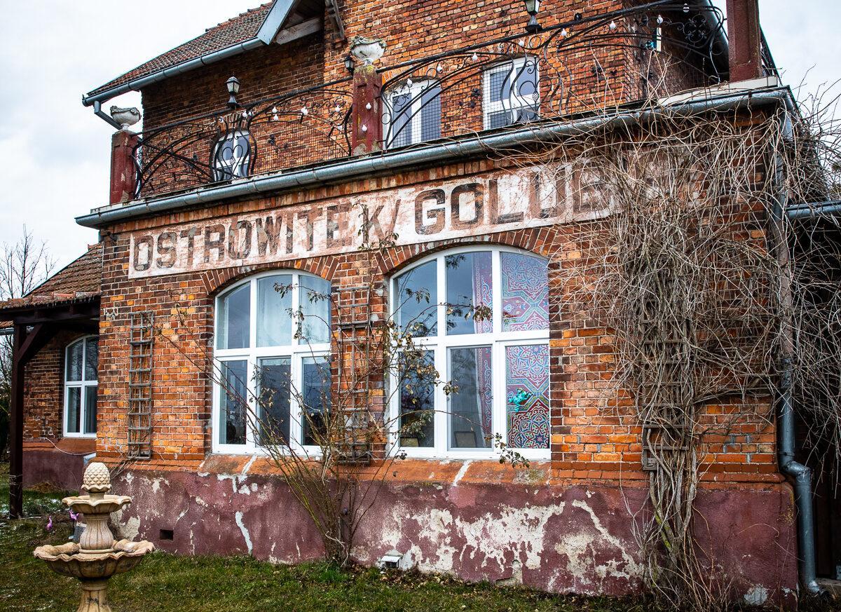 Ostrowite_zabytkowa_stacja_PKP zabytkowa stacja PKP, budynek en face, lampy, pole