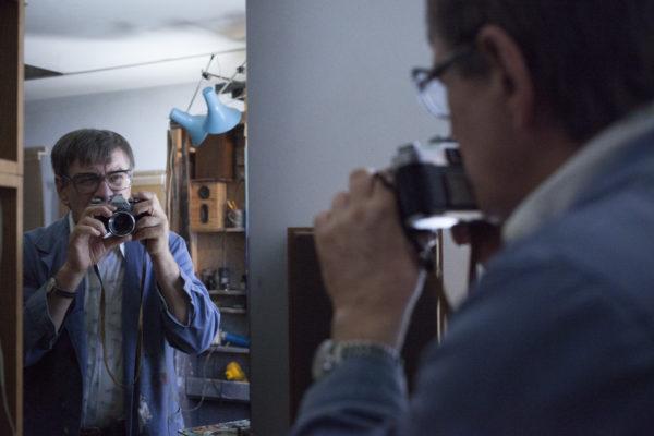 mężczyzna z aparatem przed lustrem