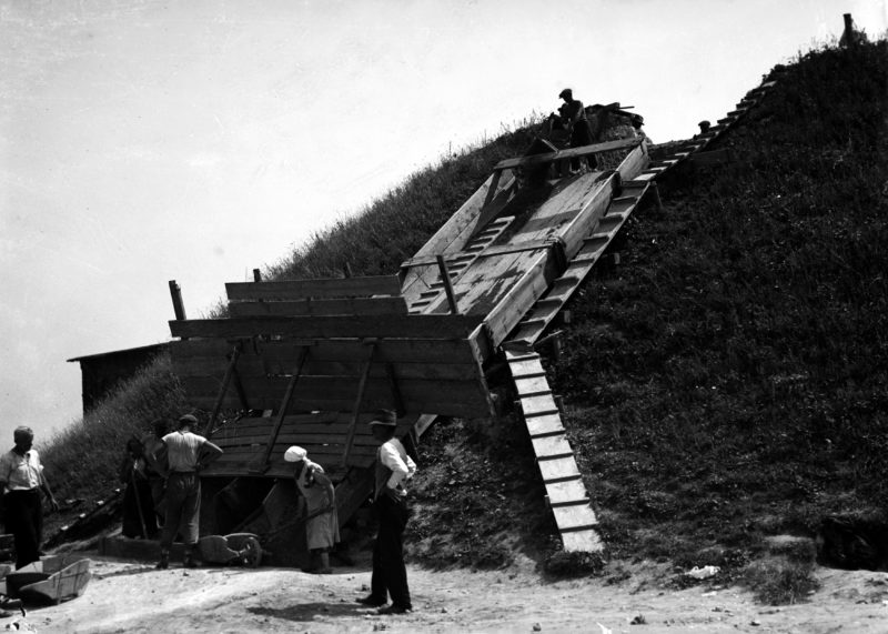 KOPIEC_KRAKUSA5 Widok rozkopanego kopca podczas prac badawczych, osoby przy pracy.