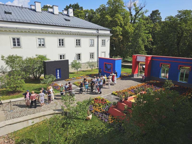 Kolorowe kwiaty i fragment scenografii przypominającej dom artystki