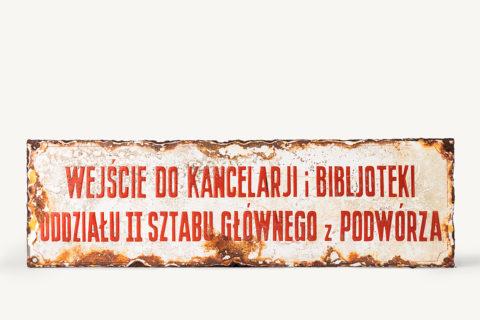 Tabliczka żelazna, zewnętrzna, informacyjna z napisem "wejscie do kancelarii i biblioteki oddzielu II Sztabu Glownego z pódworza"
