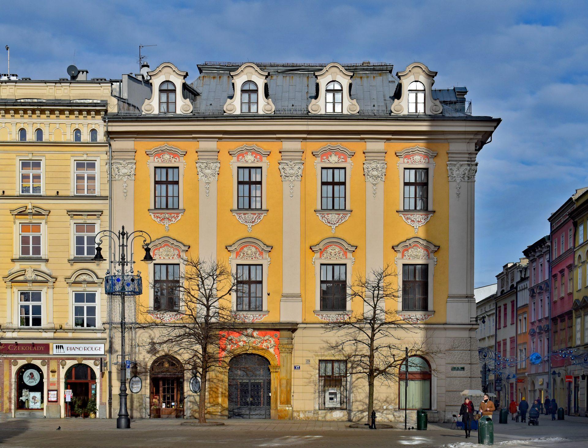 Hotel Drezdeński (tzw. Kamienica Margrabska) Hotel Drezdeński (tzw. Kamienica Margrabska). Elewacja budynku żółta z licznymi zdobieniami szaro-pomarańczowymi wokół okien, na dachu lukarny