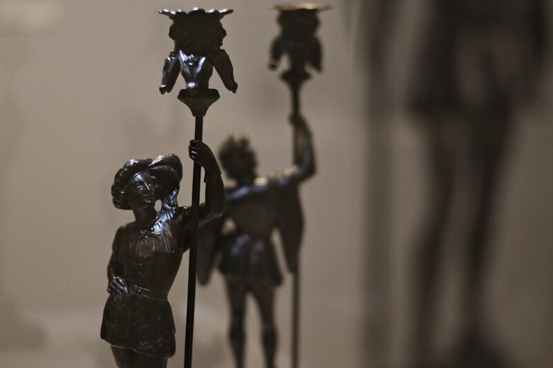 Świecznik w kształcie młodego mężczyzny z drzewcem zakończonym obsadką na świecę, odlew żeliwny, montowany, 33,5x12,8x12,5 cm, XIX w.