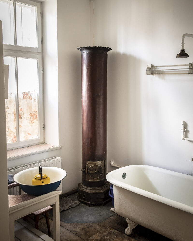 Oryginalna (nieczynna) armatura nad wanną i mosiężny piec w łazience na piętrze
