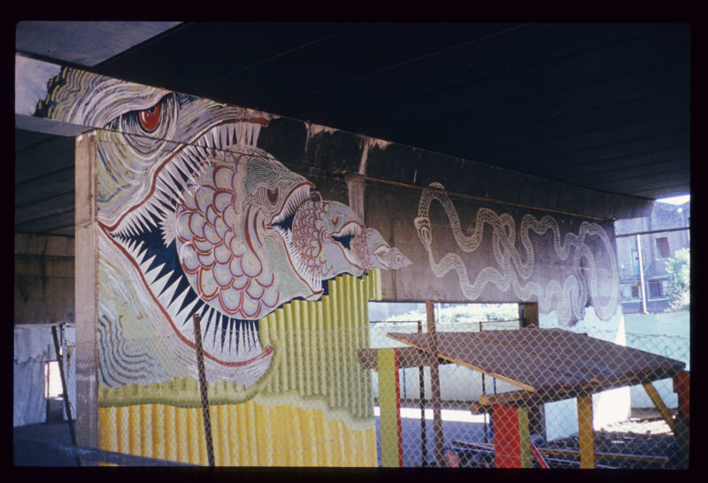 Władysław Hasior, „Notatnik fotograficzny”, z około 1965–1998 roku, z serii o tytule „Podróżna Pop Art”. Mural przedstawiający podobną do ryby istotę z otwartymi szeroko ustami, z niej wychodzi kolejna "ryba", z niej kolejna, później następna i końcowa. Obok samo zjadający się wąż.