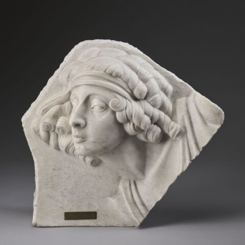 Janina Broniewska rzeźba pod tytułem „Portret kobiety” z 1922 roku. W wykonanej z marmuru rzeźbie jest portret kobiety z lokami i chustką na głowie.