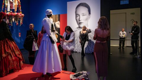 Od lewej: Manekiny ubrane w stroje ludowe, po środku zwiedzający robiący zdjęcia, po prawej pracownicy pilnujący przestrzeni ekspozycji