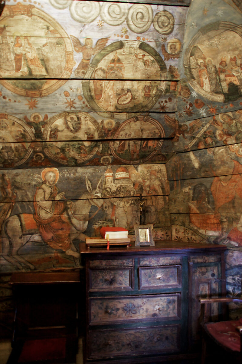 Wnętrze cerkwi w Powroźniku. Na drewnianej ścianie przedstawione sceny religijne.
