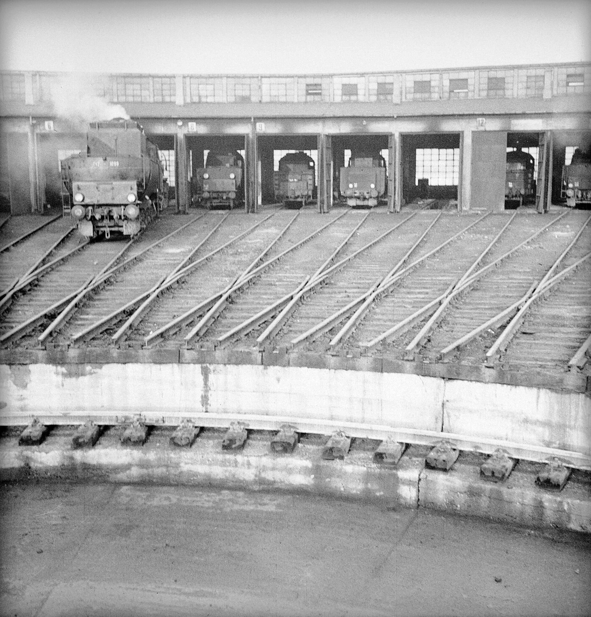 PIC_51-108-2 Budynek parowozowni Warszawa Praga. Parowozy: z lewej Ty 2, obok w głębi Ty 45. Na pierwszym planie fragment obrotnicy. Warszawa, 1958 r.