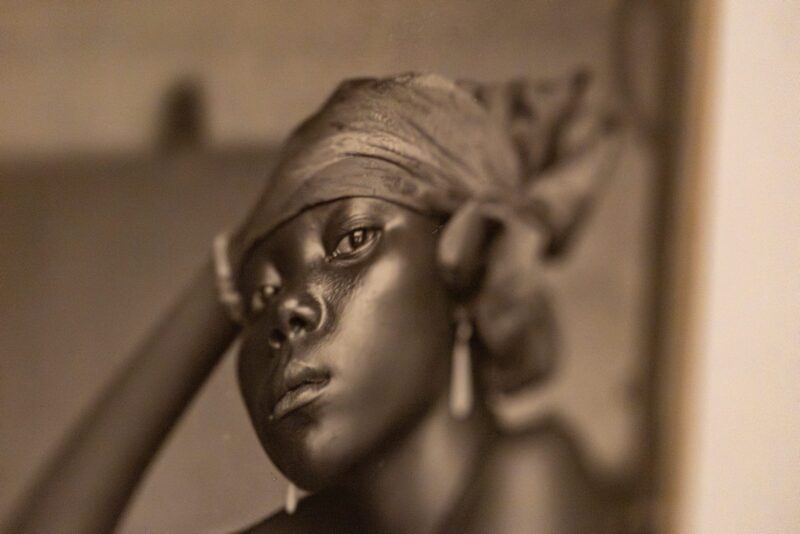 Zbliżenie na zdjęcie podpisane jako „Młoda Mu**ynka, Afryka”, wystawa „Wybielanie”