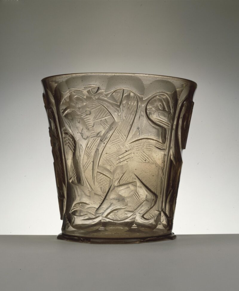 505376001 Szklanka świętej Jadwigi pokazana od strony dekoracji przedstawiającej orła. Po jej bokach jest lew i skrzydlaty gryf. Pochodzi z Bliskiego Wschodu.