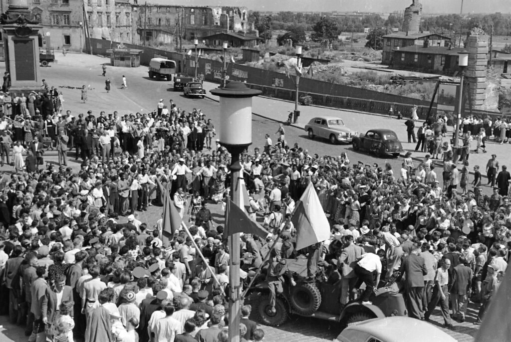V Światowy Festiwal Młodzieży i Studentów. Uczestnicy na placu Zamkowym przy kolumnie Zygmunta. W tle ogrodzony plac po zburzonym Zamku Królewskim. Warszawa, sierpień 1955 r.