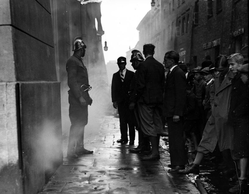 PIC_1-G-6785-2___OBR Pożar piwnicy w Rynku, przy Kościele Mariackim. Mieszczenie przyglądają się pracy strażaków. Kraków, sierpień 1933 r.