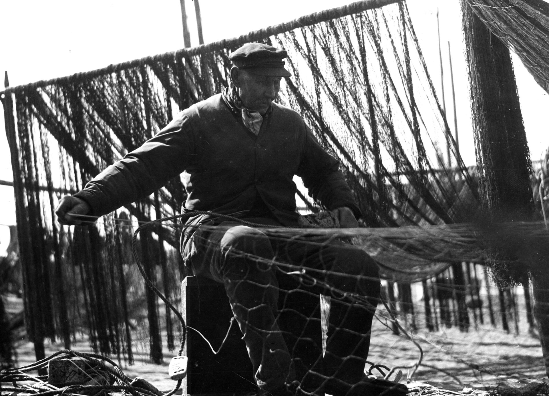 Rybak kaszubski podczas naprawiania sieci. P&oacute;łwysep Helski, lata 30. XX w.